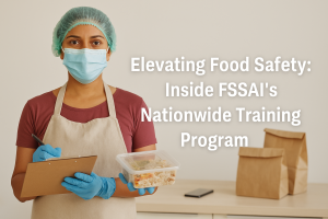 Indian woman food handler wearing mask and gloves, holding a food container and clipboard as part of FSSAI’s food safety training initiative.